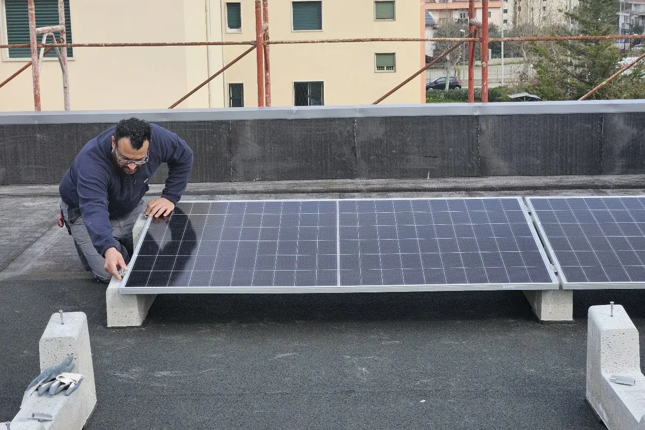 Tecnico di Madeo Impianti fissa un modulo fotovoltaico su struttura zavorrata