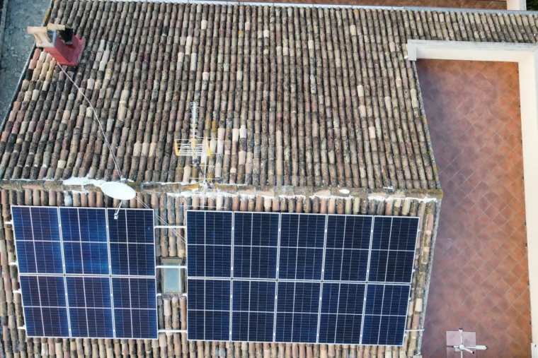 Vista dall'alto dei due campi di moduli fotovoltaici posati sulla falda in coppi di un'abitazione