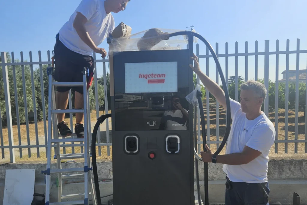 Due tecnici rimuovono l'imballo dalla colonnina e sistemano i cavi di ricarica
